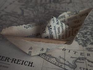 A folded paper boat made of newspaper.